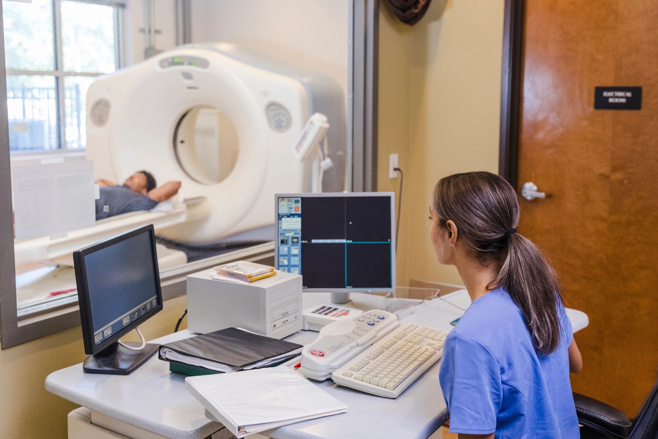Imaging professional reviewing scan information at a workstation