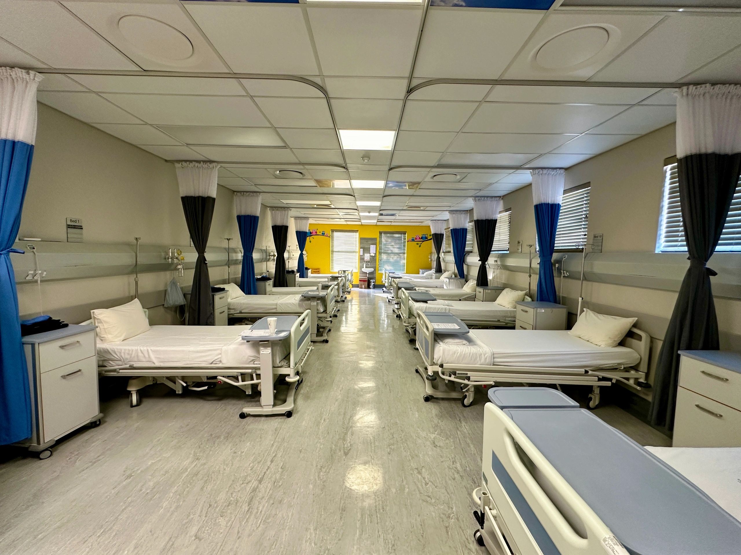 Hospital beds in an empty ward representing patient transport equipment