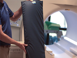 A figure holding up an example of an MRI foam thermal barrier pad. Image links to product page.