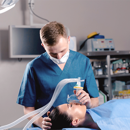 A male anesthesiologist is giving a female patient anesthesia through gas.