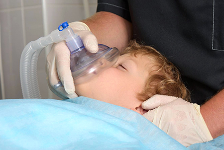 A young pediatric patient is given anesthesia through gas.
